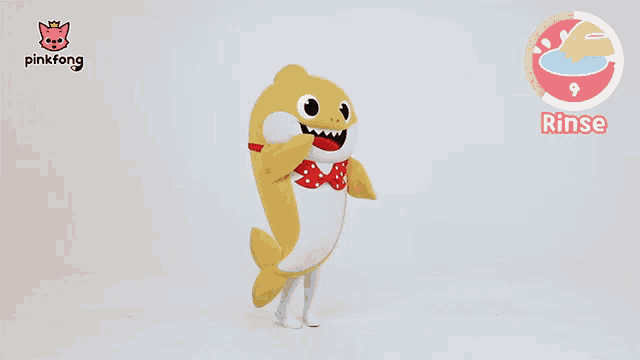 a baby shark mascot is standing in front of a pinkfong logo