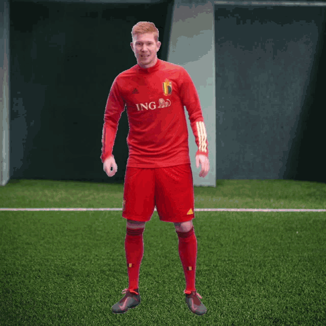 a soccer player wearing a red jersey with ing on it