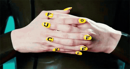 a close up of a woman 's hands with yellow nails and the letters f o t and k painted on them