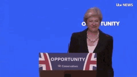 a woman in a black suit is standing in front of a blue screen that says opportunity