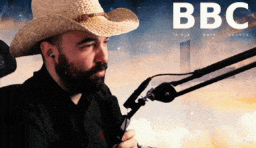 a man wearing a cowboy hat is sitting in front of a microphone with bbc bible boys church written in white letters