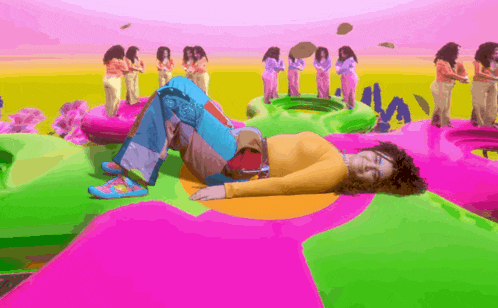 a woman is laying on her stomach on a colorful surface surrounded by other women