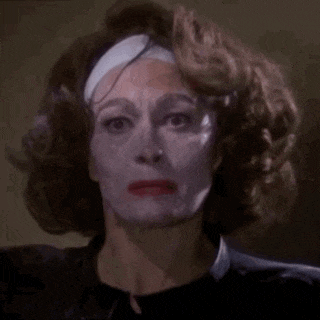 a woman with white paint on her face and a bandage on her head .