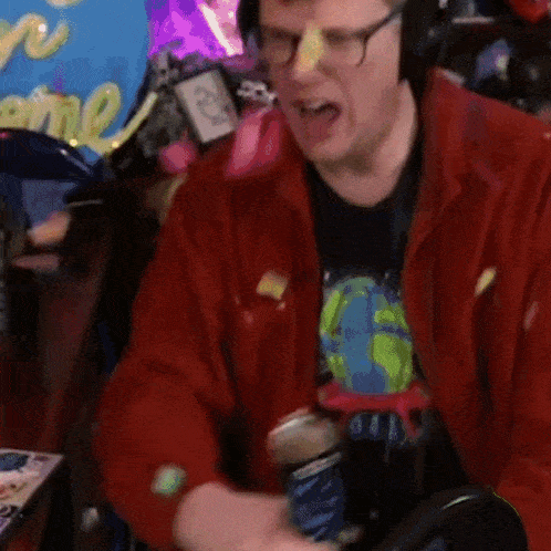 a man wearing glasses and headphones is sitting in front of a sign that says " welcome "