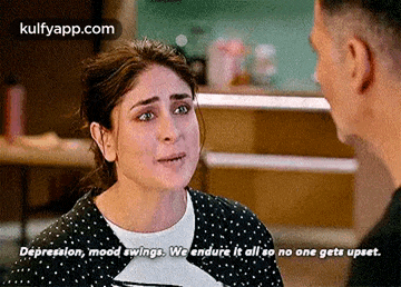 a man and a woman are talking to each other in a kitchen and the woman is crying .