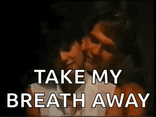 a man and a woman are kissing in a dark room with the words `` take my breath away '' written on the bottom .