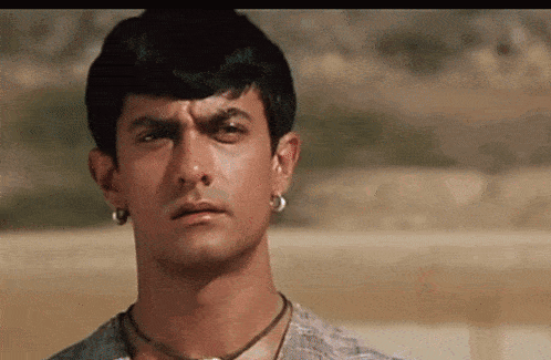 a close up of a man 's face with earrings on