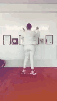 a woman is rollerblading on a red carpet in front of a wall with pictures on it