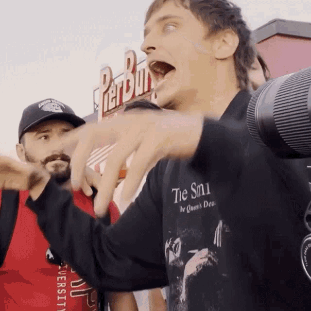 a man wearing a black shirt that says " tie smi " on it