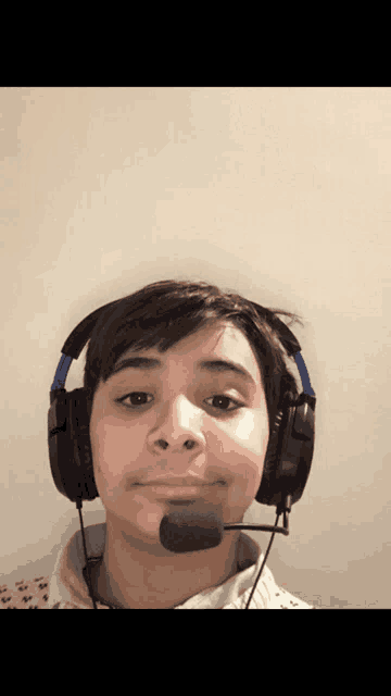 a young boy wearing headphones and a microphone on his neck