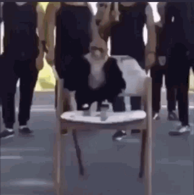 a group of people are standing around a cow sitting on a chair .