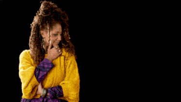 a man in a green shirt stands next to a woman in a yellow sweater on a black background