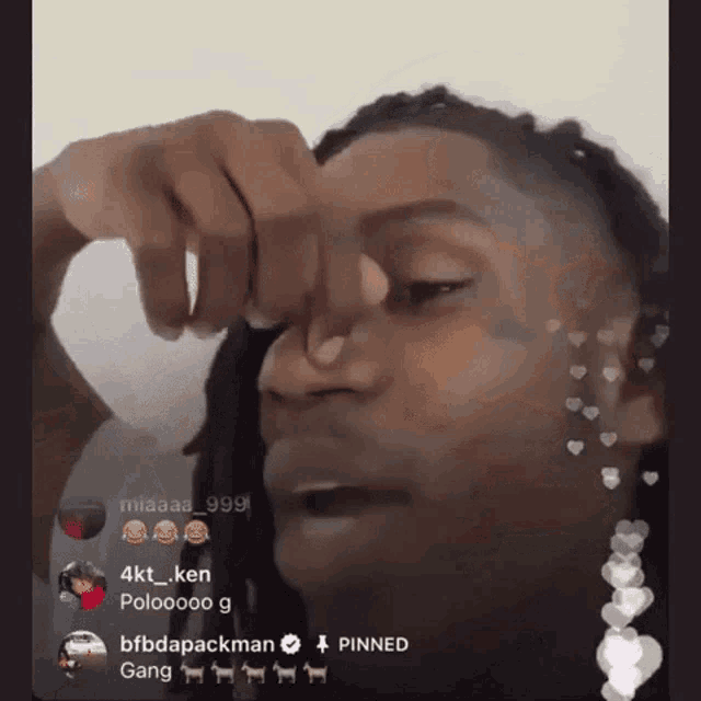 a man with dreadlocks is holding his nose in front of a crowd of people