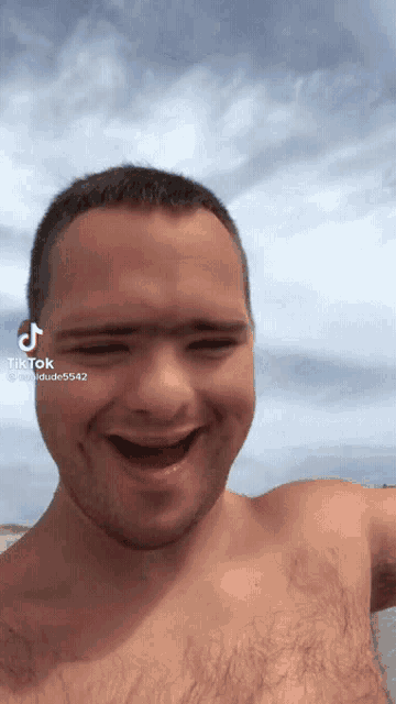 a man without a shirt is making a funny face and has a tik tok sticker on his face