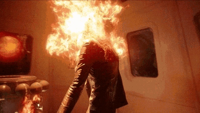 a person with flames coming out of their head in a dark room