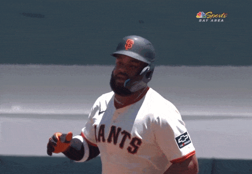 a baseball player wearing a giants jersey stands on a field