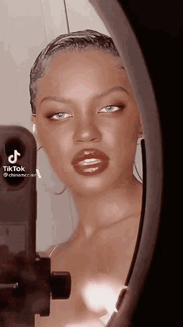 a woman taking a picture of herself in a mirror with tiktok written on the bottom right