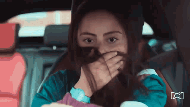 a woman in a car covering her mouth with her hand and a cn logo in the background