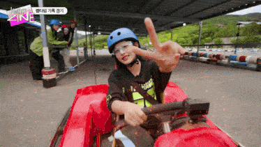 a person wearing a helmet and goggles giving a peace sign