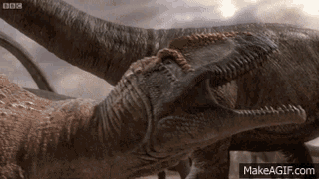 a couple of dinosaurs standing next to each other with bbc written on the bottom right