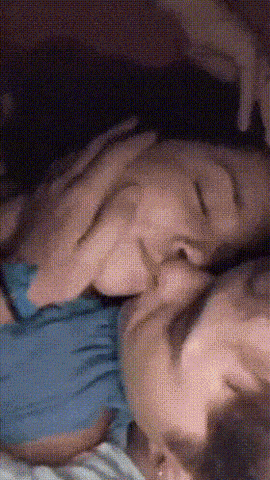 a person laying on a bed with their head on another person 's lap