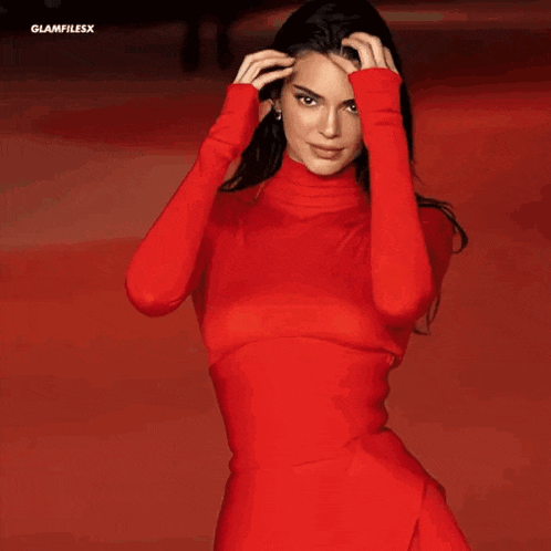 a close up of a woman wearing a red turtleneck .