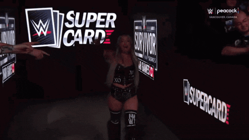 a female wrestler is walking into a wrestling ring with a supercard sign behind her