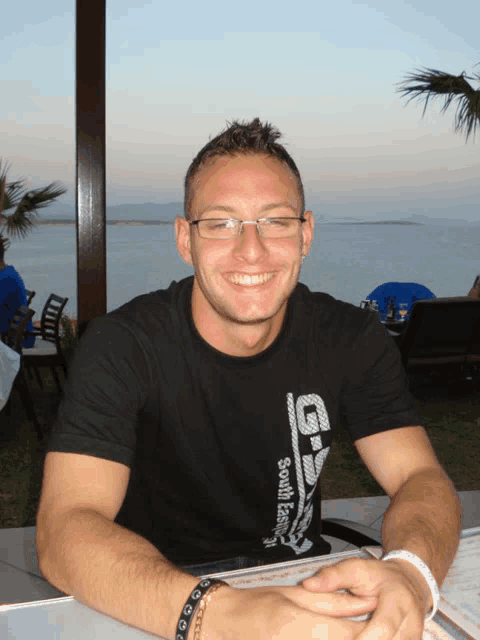 a man wearing a black shirt that says south eastern smiles at the camera