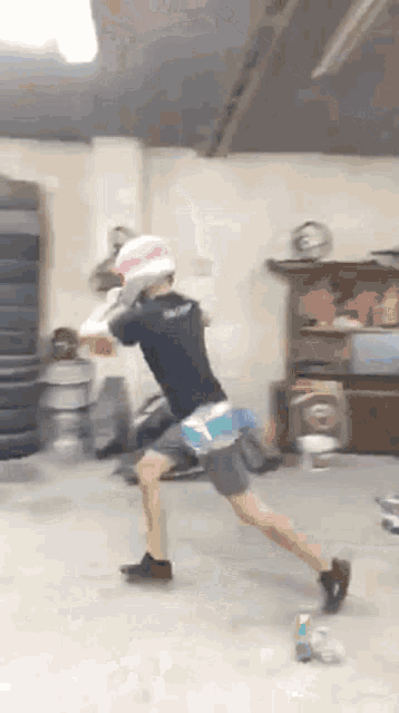 a man wearing boxing gloves is standing in a garage