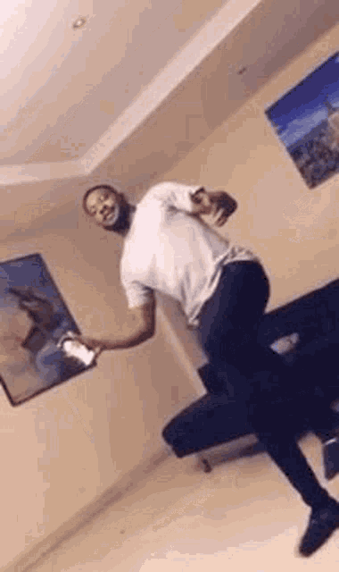 a man is standing on one leg in a living room while holding a remote control .
