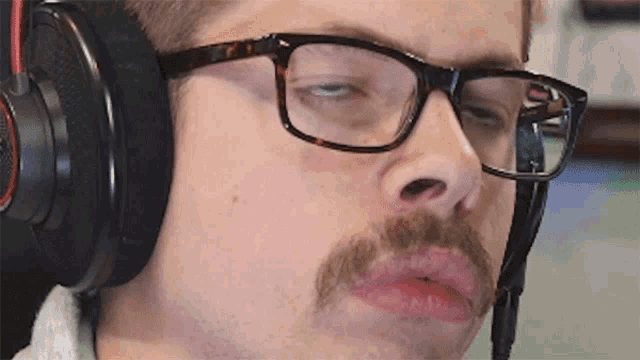 a man with glasses and a mustache is wearing a pair of headphones