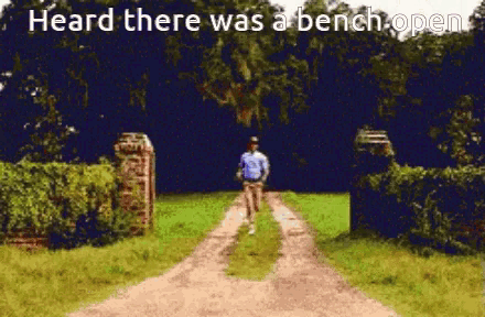 a man walking down a dirt road with the words heard there was a bench open