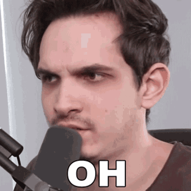 a man is talking into a microphone with the word oh written on his face