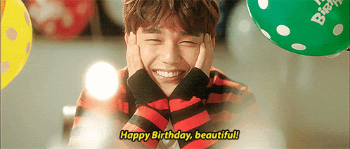 a young man is smiling with his hands on his face and says happy birthday beautiful .