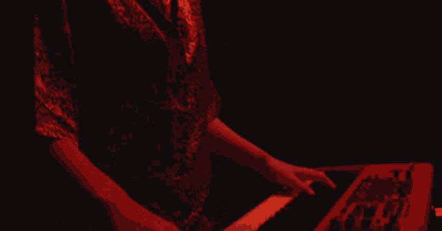 a person in a red shirt playing a keyboard