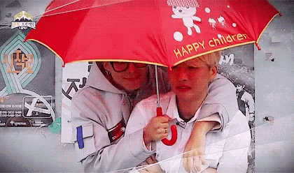 a man is holding a red umbrella over a woman .