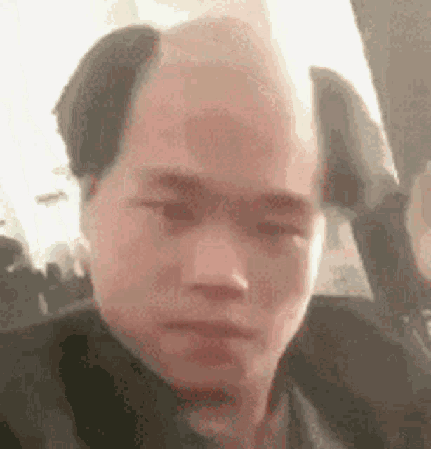 a man with a shaved head is taking a selfie on a plane .