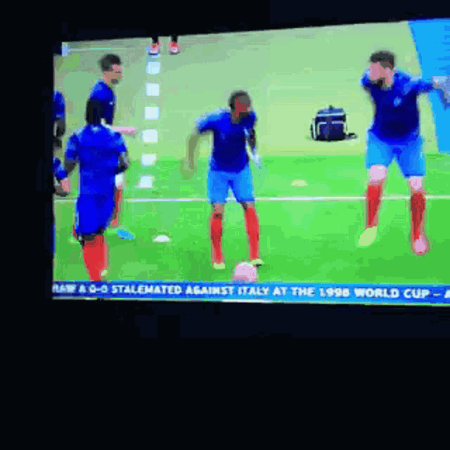 a group of soccer players are jumping in the air on a field