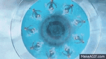 a group of people are swimming in a circular pool .