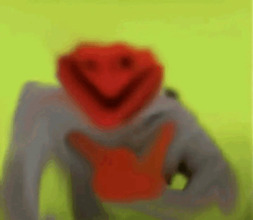 a blurry picture of a muppet with a red face and a smiley face .