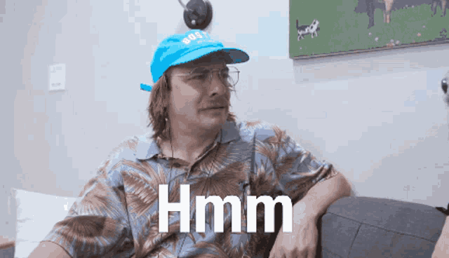 a man wearing a blue hat with the word hmm written on it