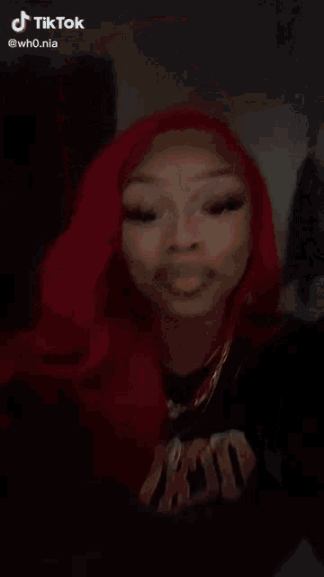 a close up of a woman 's face with red hair making a funny face .