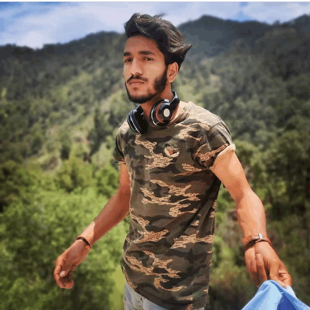 a man wearing headphones and a camouflage shirt