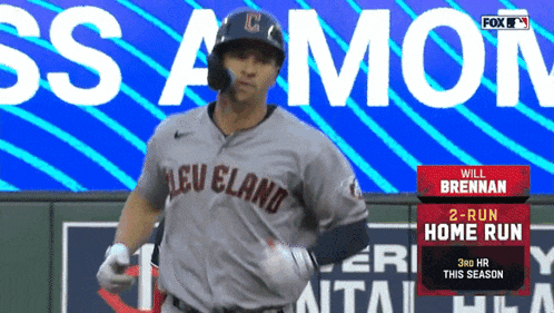 a baseball player in a cleveland uniform runs towards a sign that says will brennan