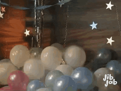 a bunch of balloons are sitting on top of each other in a room with stars .