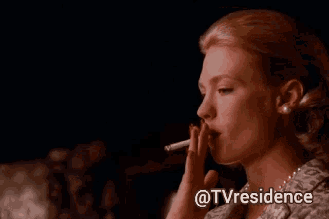 a woman is smoking a cigarette in a dark room with the words @tvresidence above her