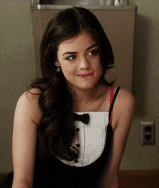 a woman wearing a tuxedo and a bow tie is smiling .