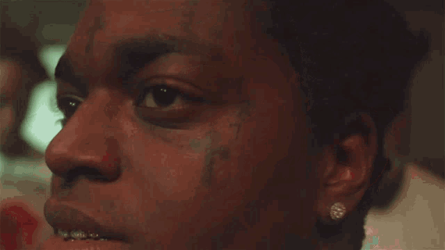 a close up of a man 's face with a tattoo of a lightning bolt on his forehead