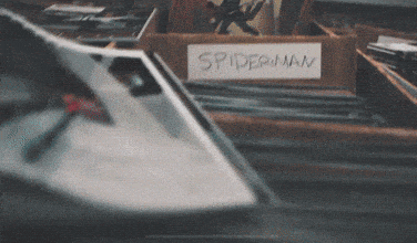 a box labeled spider-man sits in a pile of books