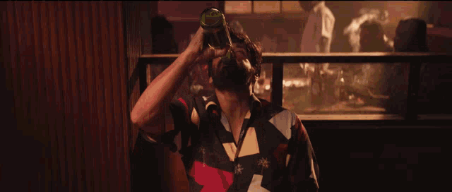 a man is holding a bottle of beer in his hand